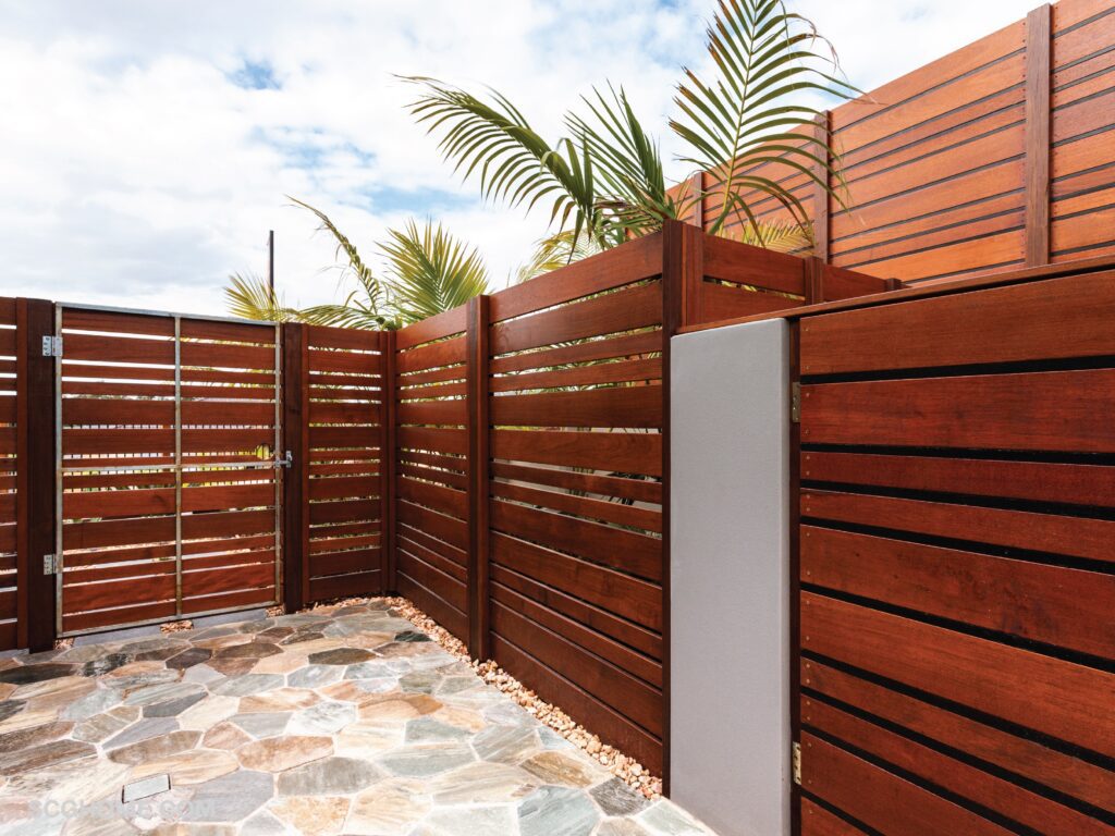 ภาพ: รั้วไม้ธรรมชาติสีเข้ม แผ่นเล็กแผ่นใหญ่สลับกันให้ดูมีมิติมากยิ่งขึ้น